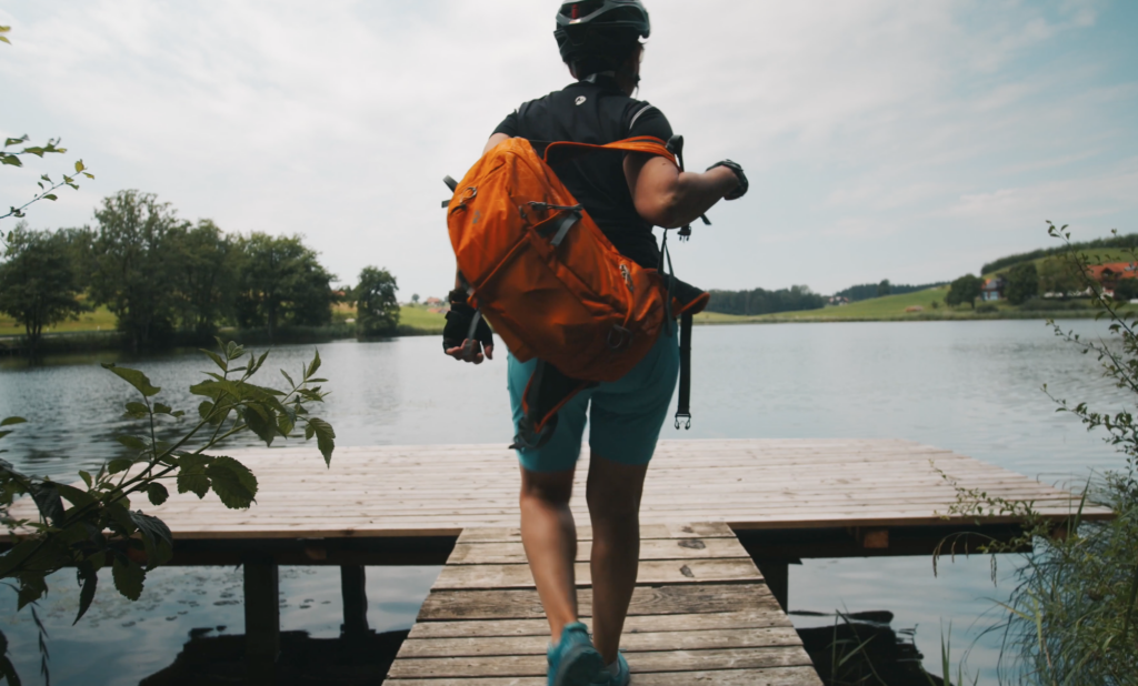 Eine Frau in Sportkleidung läuft auf einem Steg an einem See