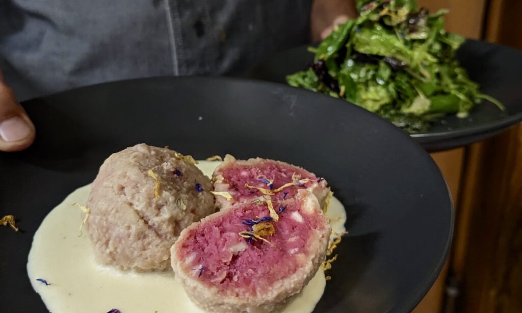 Knödel und Salat auf schwarzem Teller